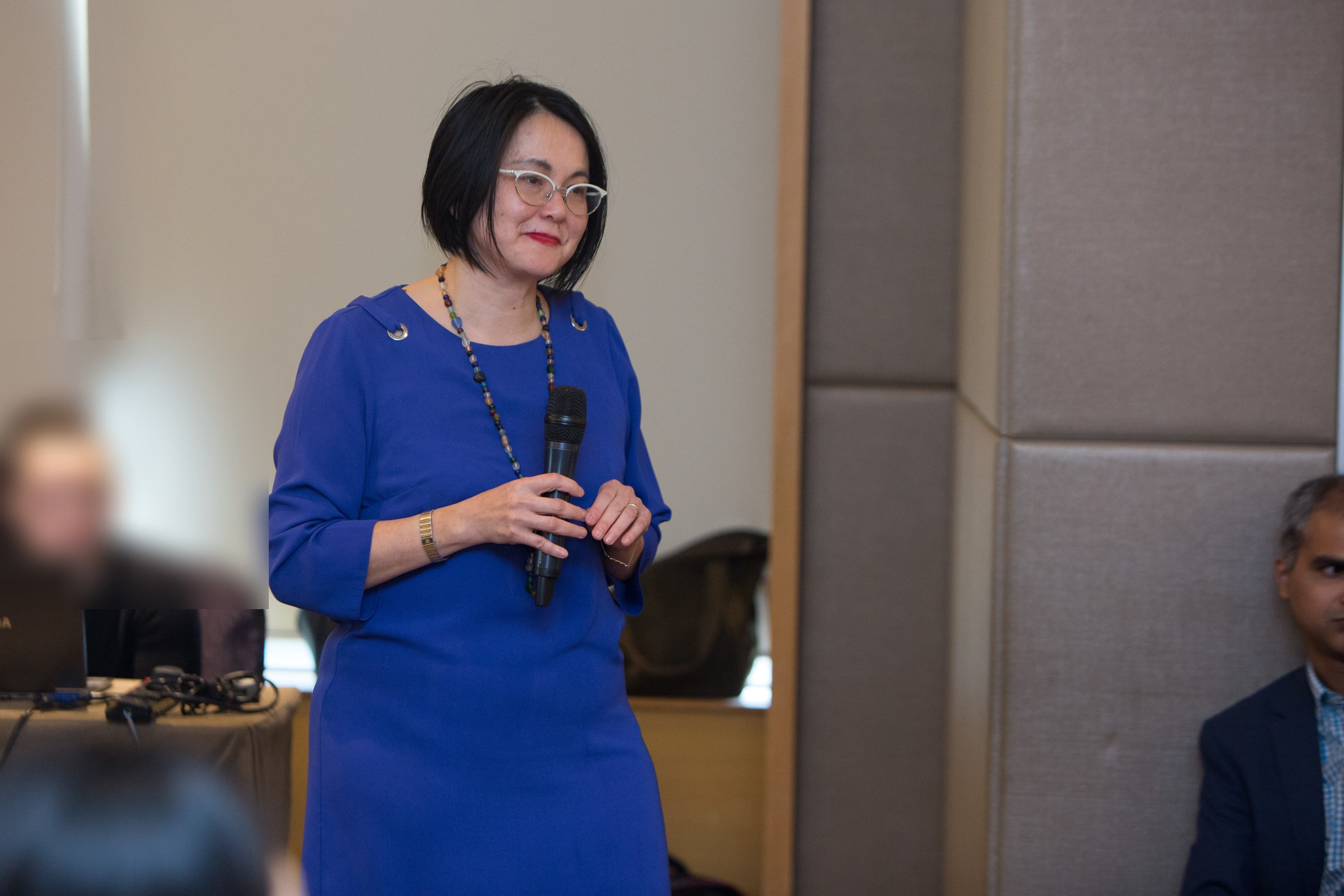 Evelyn Foong presenting with a microphone at a Zurich event
